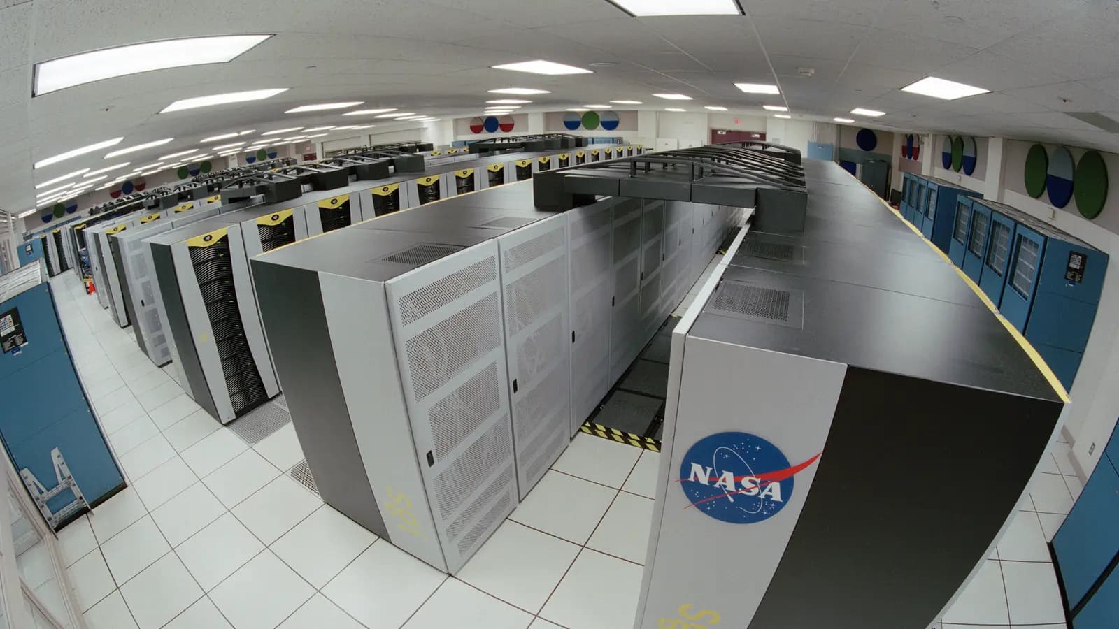 Sala de computação de alto desempenho com fileiras de equipamentos de um supercomputador.