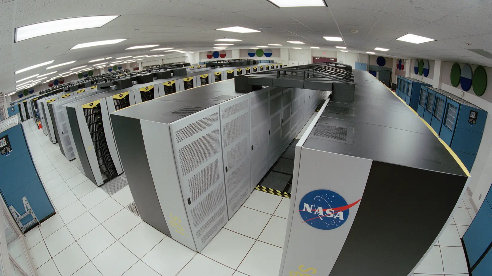 Sala de computação de alto desempenho com fileiras de equipamentos de um supercomputador.